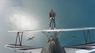 Man Walks on Wings of Biplane as It Flies in Air - 1057691