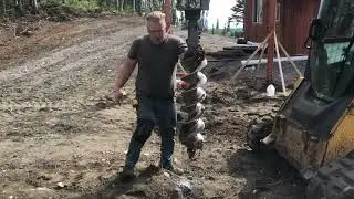 Digging fence post holes with skidsteer auger.