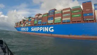 Giga container ship is disembarking her pilot while leaving the port of Rotterdam