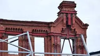Old brick building reconstruction in Moscow with steel beams and facade support