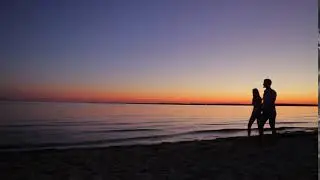 evening walk of lovers along the beach guy and girl walking at sunset on the ocean coast
