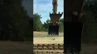 Excavator laying laminated mats power line construction