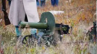 a military man in white coat standing by the machine gun