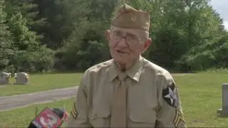 World War II vet places flags on gravesites of fallen servicemen