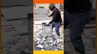 Skilled worker precisely chisels a stone slab, shaping clean lines amid scattered rock fragments.