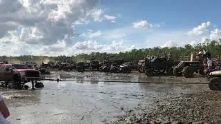 Big truck towing another big truck out of the mud at redneck yacht club