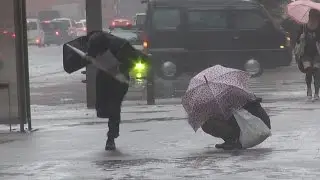 台風18号暴風雨に座り込む女性。The woman who was not able to endure the rainstorm of the typhoon.