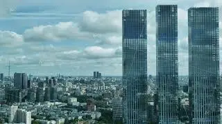 Three skyscrapers towering over Moscow cityscape under cloudy sky