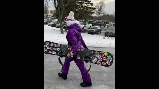 A girl in a lilac shiny ski jumpsuit with a hood. Winter shine and beauty. Girl in winter overalls