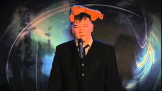 stewart lee stares into space while a stuffed toy rests on his head