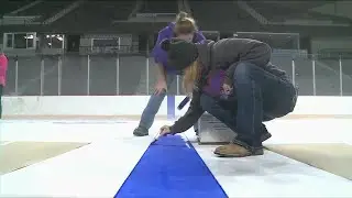 Community members etch their marks into the home rink of the Topeka Scarecrows ahead of season