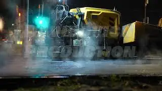 Asphalt paver machine working late at night, repairing city road surface