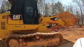 CAT 953 stacking red dirt for a stem wall foundation.