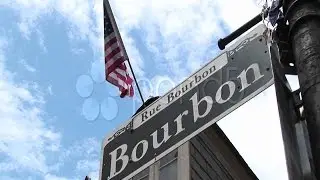 An American Flag Flies Above A Street Sign Identifying Bourbon Street. Stock Footage