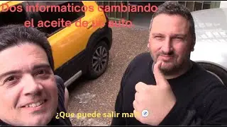 Dos informaticos cambiando el aceite de un auto