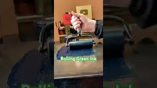 Rolling out green rubber base ink on the ink stone for letterpress printing