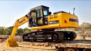 Малыш наблюдает, как папа управляет экскаватором Komatsu PC200, чтобы загрузить песок в самосвал ...