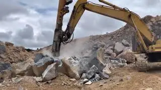 Escavadeira quebrando pedra