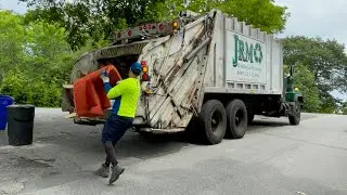 Old roaring JRM garbage truck packing heavy hillside trash