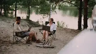 A Couple Using Laptop Computers at a Camping Site