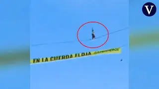Un activista de Greenpeace camina sobre una cuerda a 30 metros de altura en Madrid