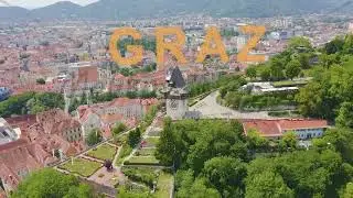 Inscription on video. Graz, Austria. Clock Tower in Graz. The historic city center aerial view. Moun