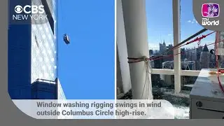 Window washing rigging swings in wind outside Columbus Circle high-rise. | CBS News New York