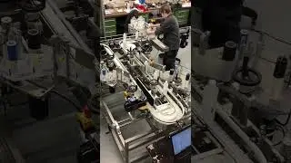 Wikkel om flessen Omega Tandem op een SES etiketteermachine. Etiketteermachines van De Groot BV