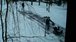 MAN TRYING USE SNOW BLOWER ON THE HILL IN THE ICE.