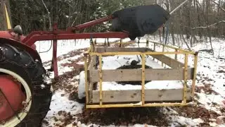 Using the three point hitch loader to clean up around the homestead