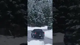 Curve on a snowy forest road,Pickup trucks turning a curve in a highway in a snowy pine forest.