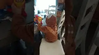 Riley playing with iron man potato Head