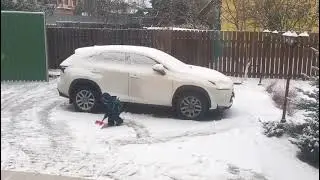 The kid cleaning snow on the parking lot 