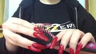 Tapping and scratching a hair brush with long red nails