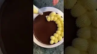 Professional pastry chef piping elegant cream on chocolate tart