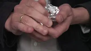 Crumpling a sheet of aluminium foil into a small ball. Free HD video footage