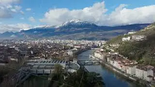 Aerial view of Grenoble, France, showcasing the Isere river, residential buildings, and the Bastille