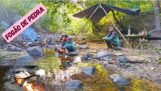 Acampamento rústico com peixe frito no fogão de pedra...