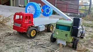 RC crane unloading and loading huge axle from truck.