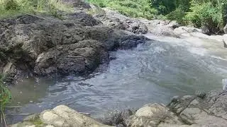 Air sungai pedesaan jernih dan deras dengan bebatuan besar