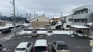 A Snow-covered Field, Road, Buildings, and Houses Beyond - Komatsu, Japan - January 27, 2026