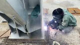 Welding steel structural columns onto base plates.