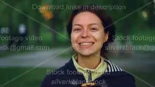 Slow motion portrait of charming young woman wearing casual clothes standing outside in park and