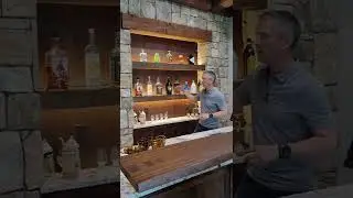 This basement bar has gorgeous floating shelves with accent lighting!