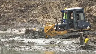 Extreme Bulldozer working in mud moving mud out clearing Canal with Excavators