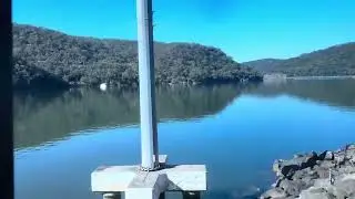 Train journey from Gosford to Hawkesbury River. Sunny day. Blue sky. Burnt bush at Koolewong. 