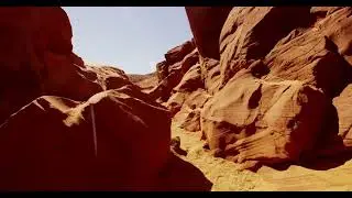 travelling shot into a natural geological formation showing orange walls and rock in 4k