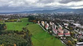 spectacular aerial perspective capturing lively apartment row with natural backdrop and dramatic sky
