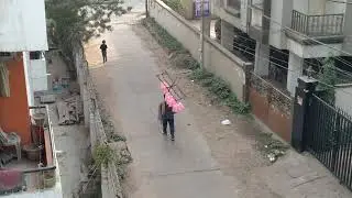 A cotton candy seller moves his handheld bell to attract customers. A pretty tough job. 