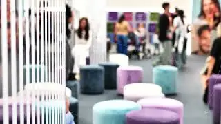 Exhibition guests interacting in a contemporary event space with soft velvet seating